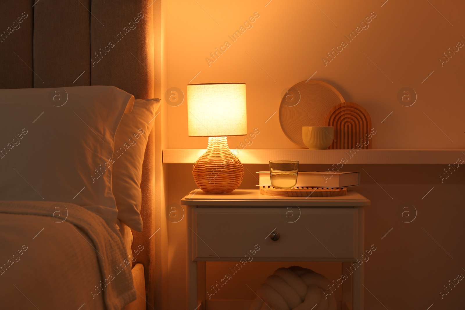 Photo of Stylish living room interior with bed, bedside table and lamp