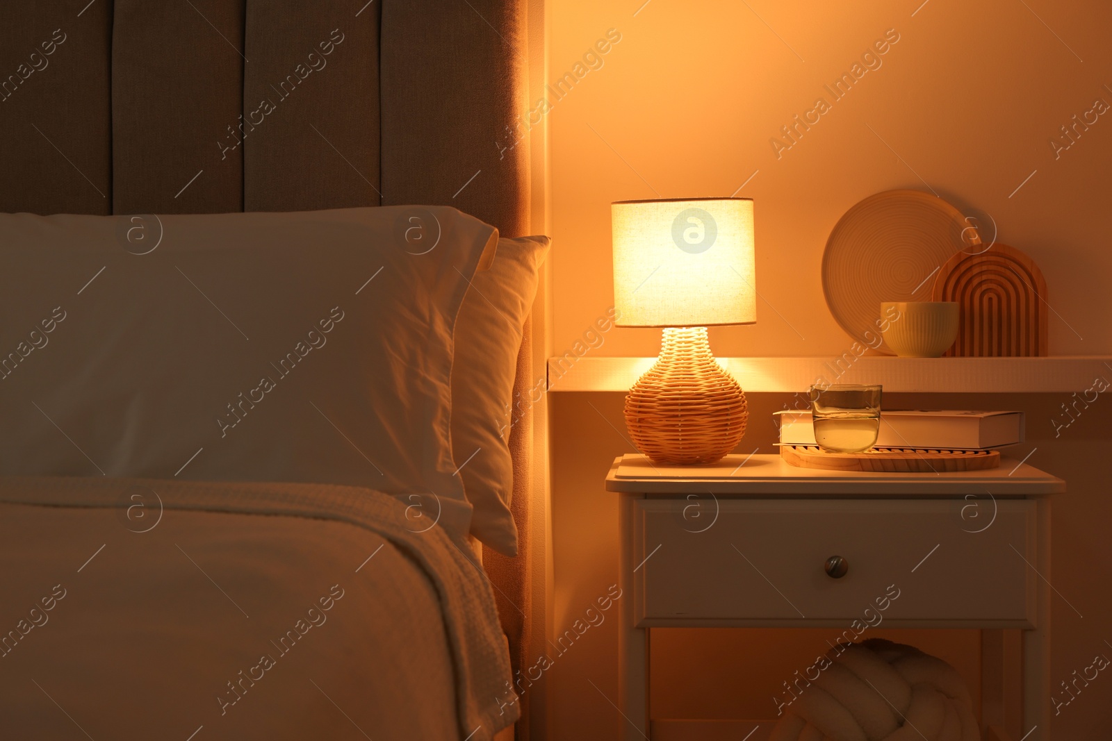 Photo of Stylish living room interior with bed, bedside table and lamp