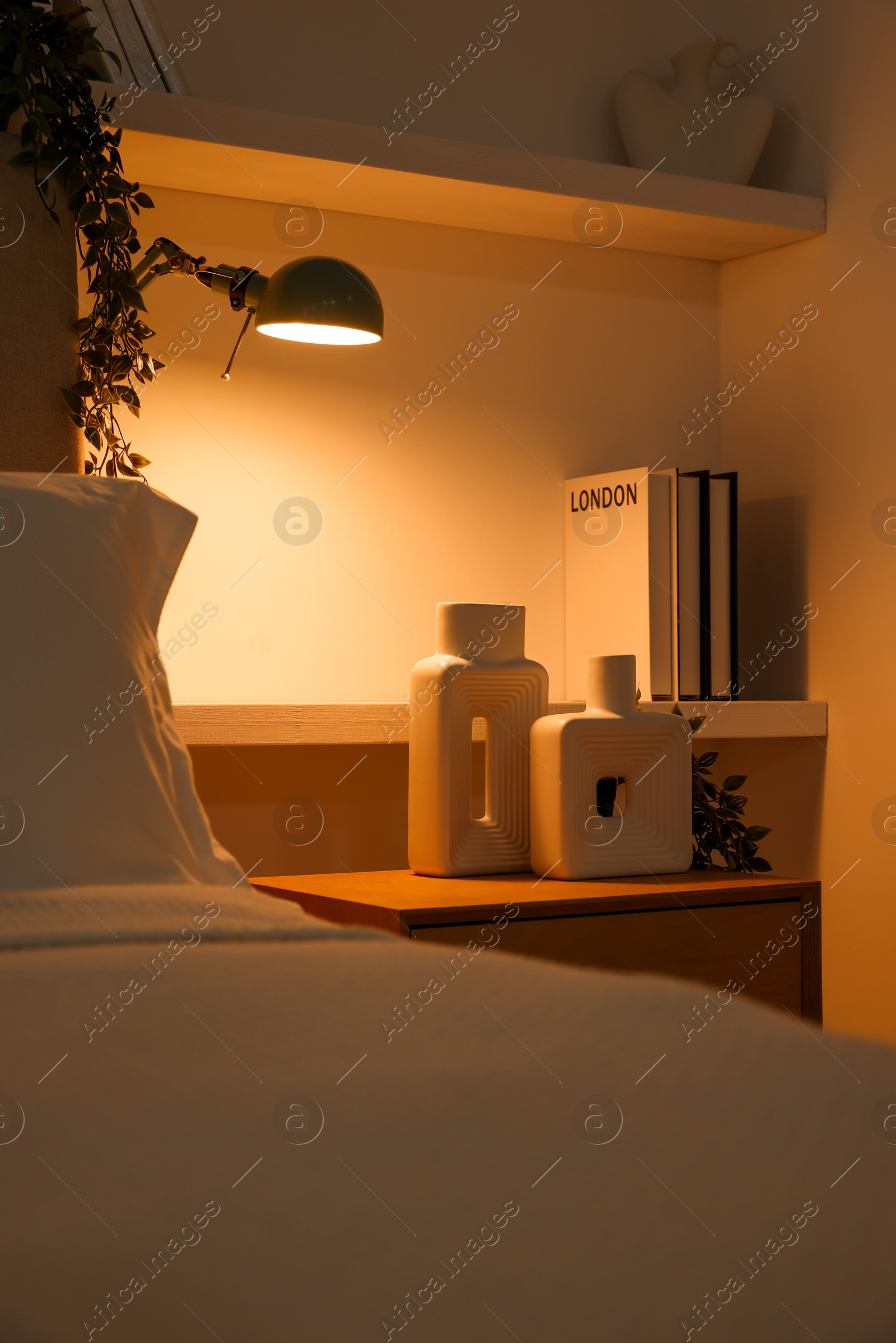 Photo of Stylish living room interior with bed, bedside table and lamp