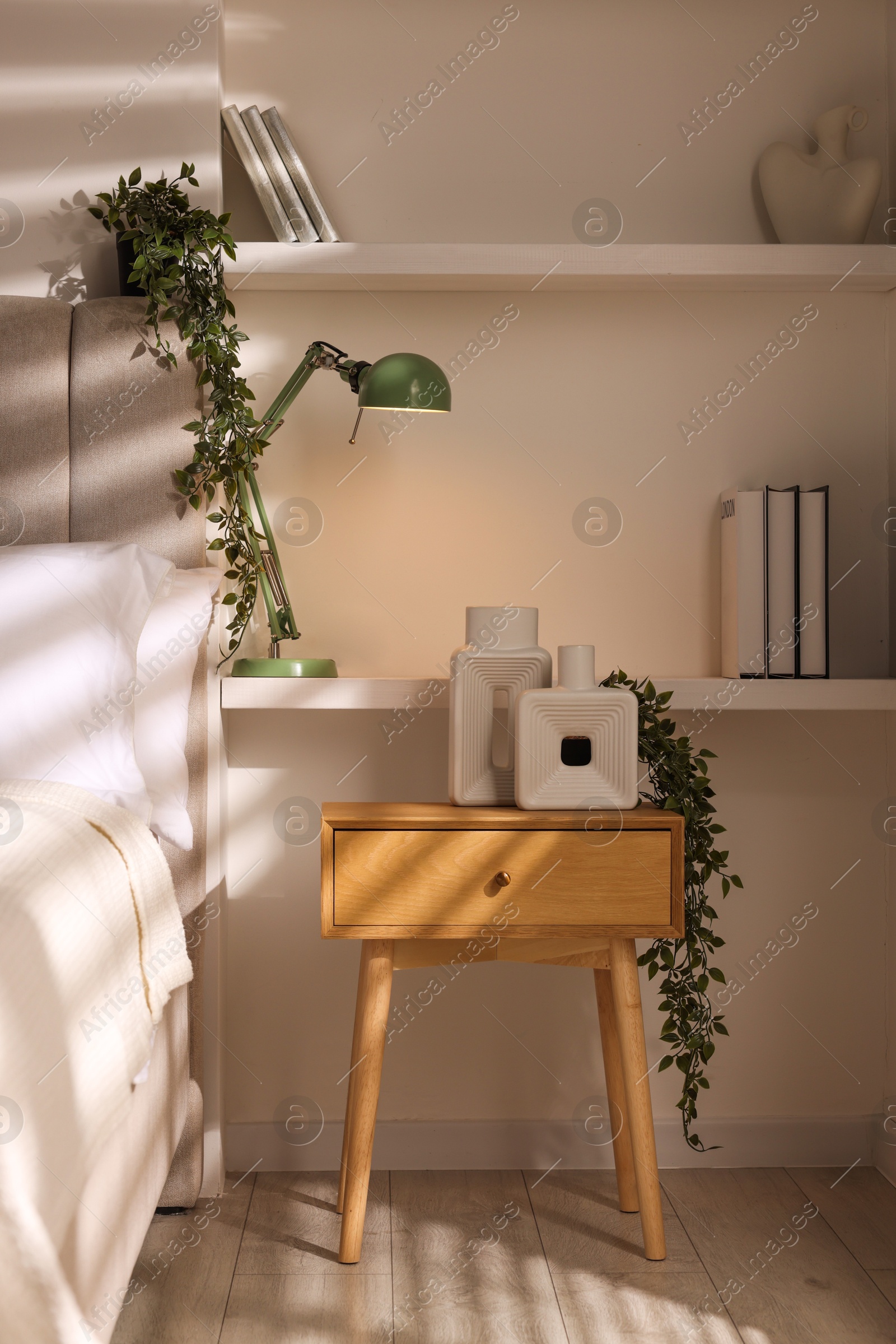 Photo of Stylish living room interior with bed, bedside table and lamp