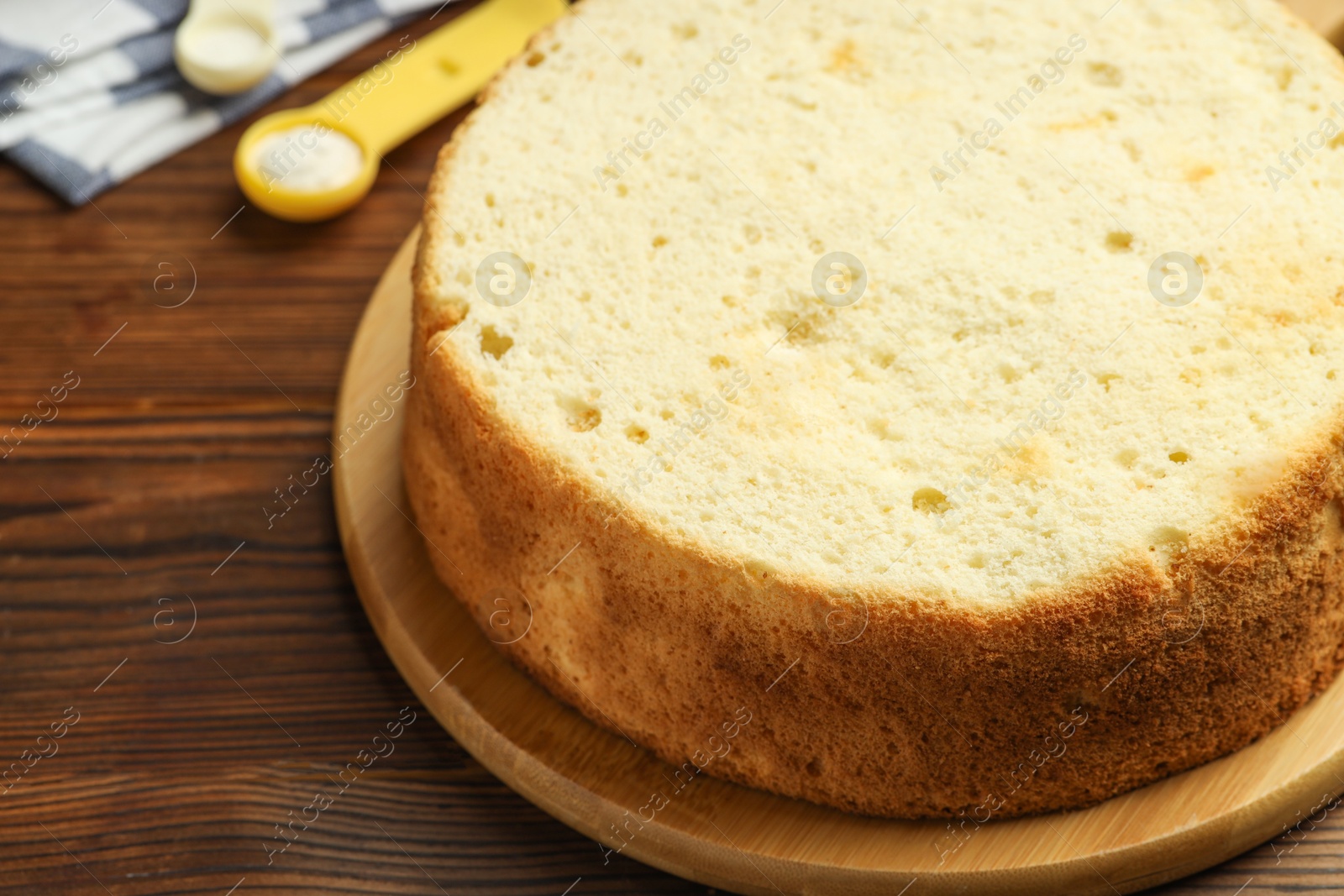 Photo of Tasty cut sponge cake on wooden table, closeup