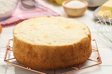 Photo of Tasty cut sponge cake on white wooden table