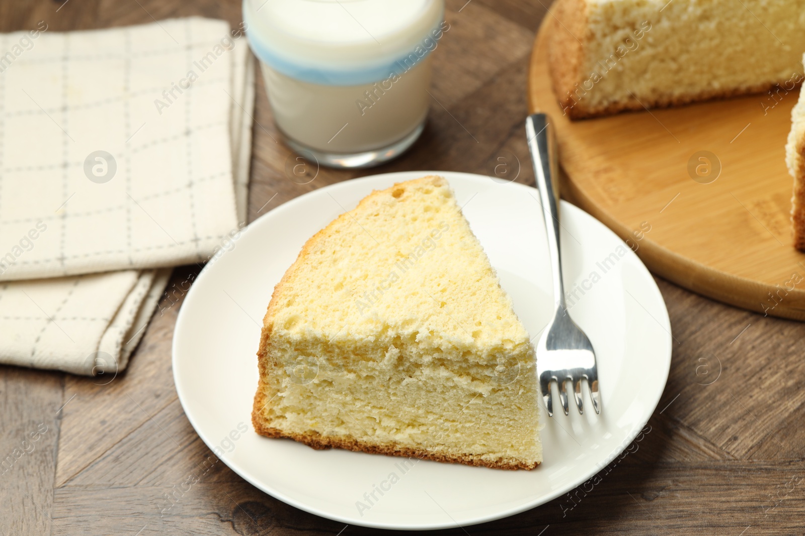 Photo of Piece of delicious sponge cake served on wooden table