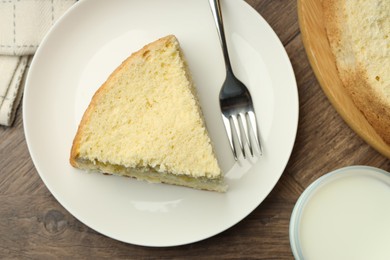 Photo of Piece of delicious sponge cake served on wooden table, flat lay