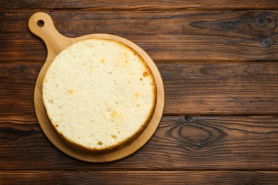 Photo of Delicious cut sponge cake on wooden table, top view. Space for text