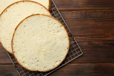 Photo of Delicious cut sponge cake on wooden table, flat lay. Space for text