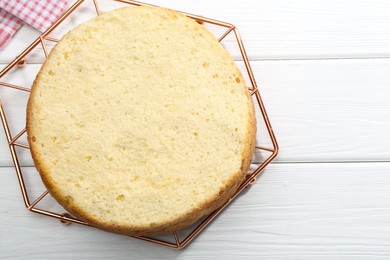 Photo of Delicious cut sponge cake on white wooden table, top view. Space for text