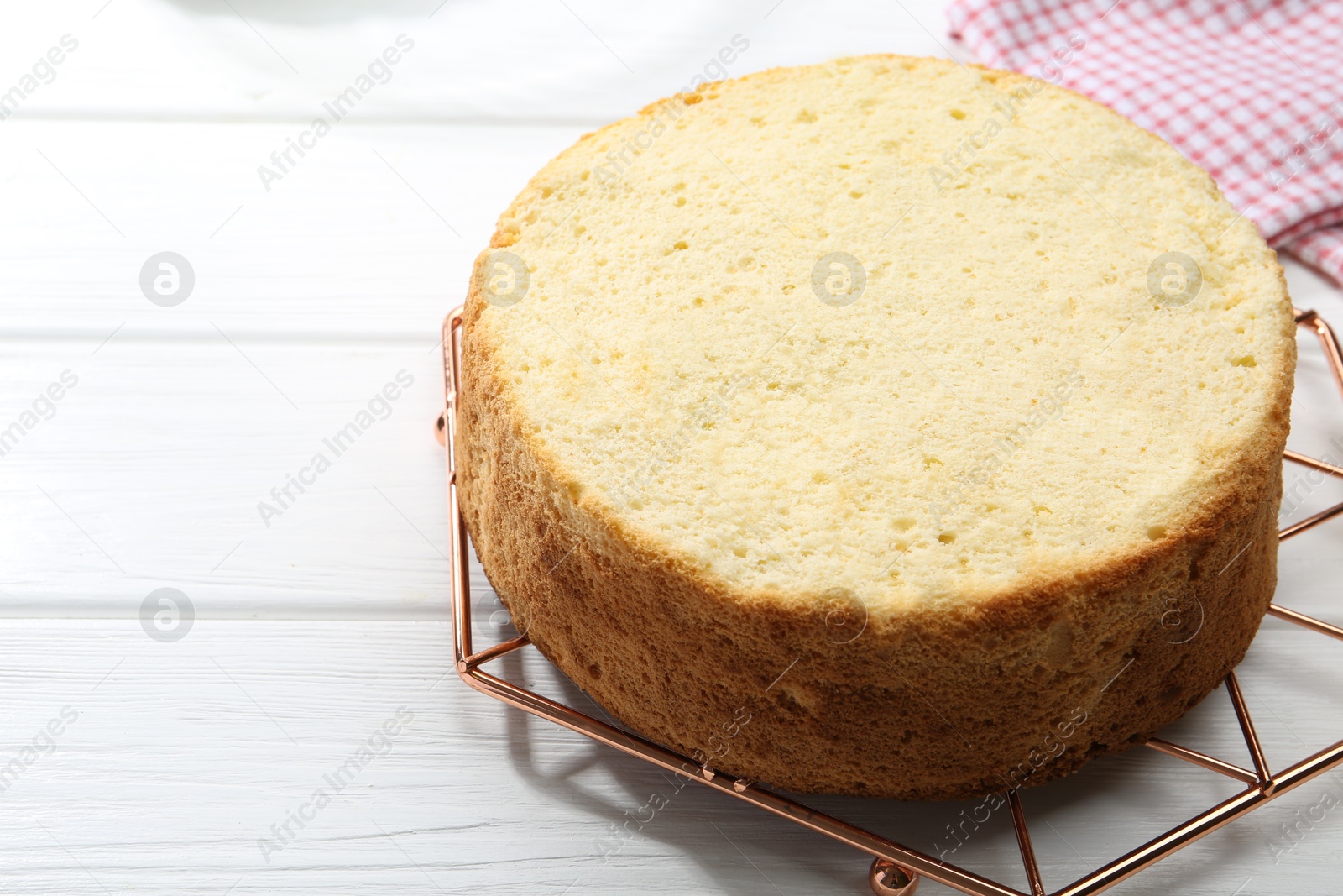 Photo of Delicious cut sponge cake on white wooden table