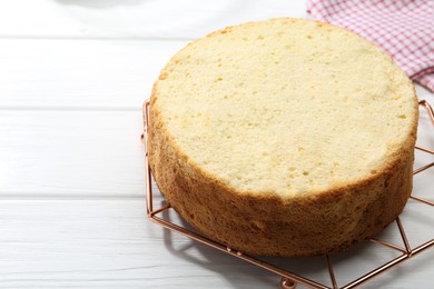 Photo of Delicious cut sponge cake on white wooden table