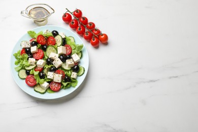 Photo of Delicious salad with feta cheese served on white marble table, top view. Space for text