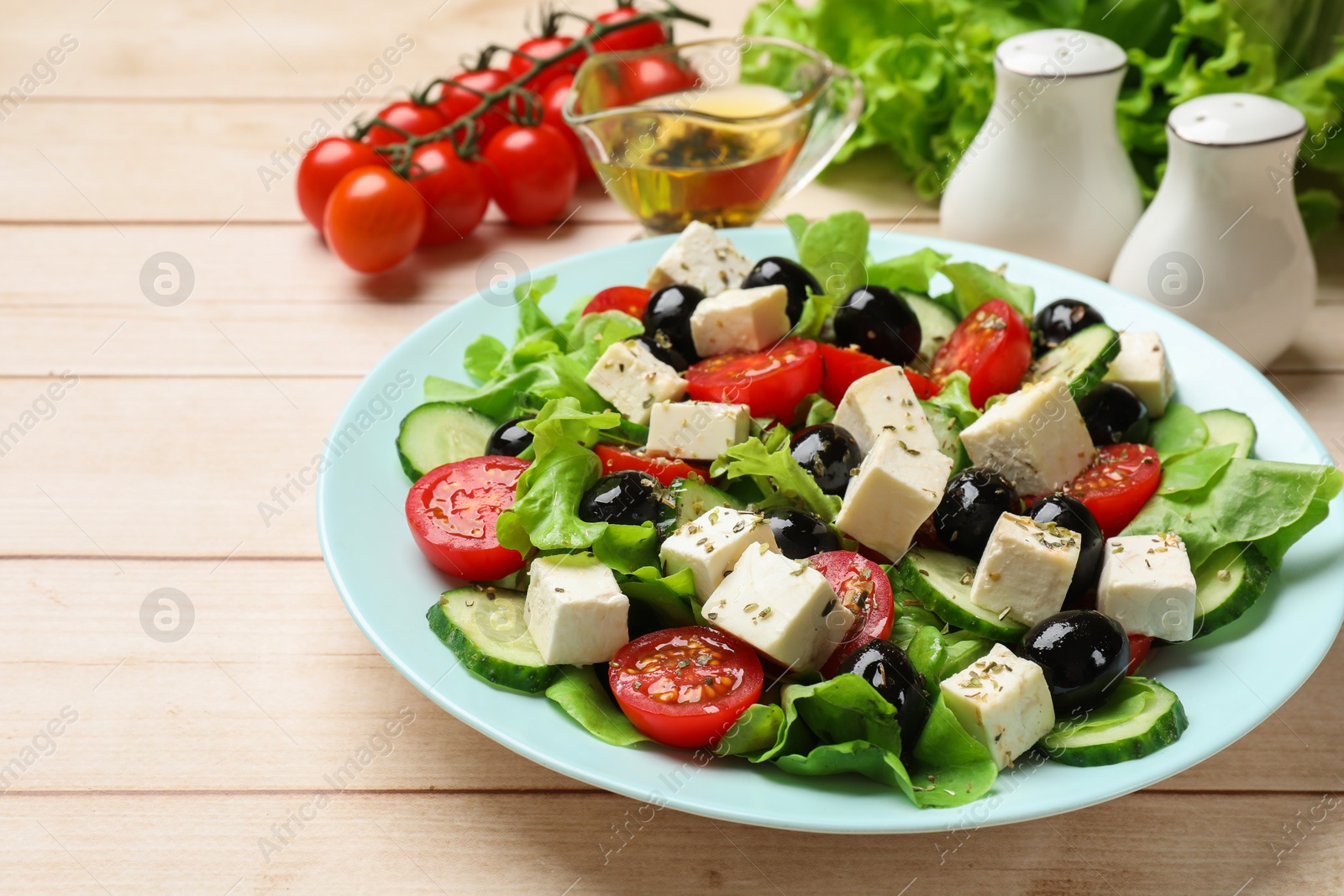 Photo of Delicious salad with feta cheese served on white wooden table, closeup