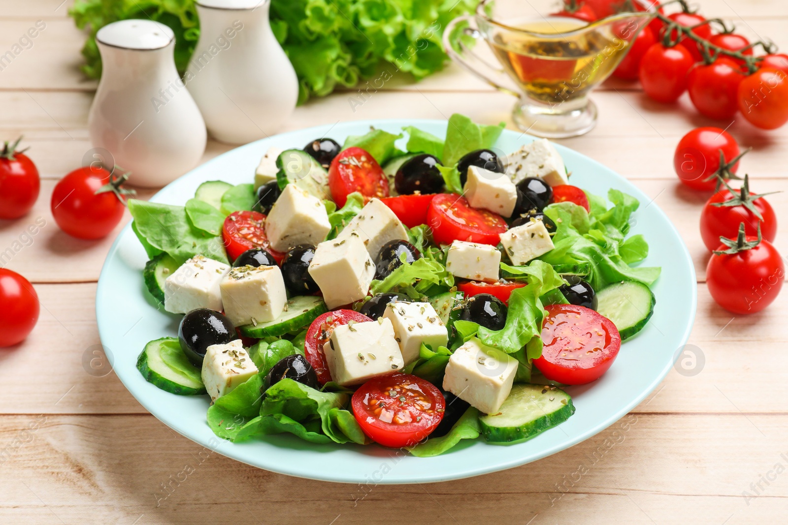 Photo of Delicious salad with feta cheese served on white wooden table, closeup