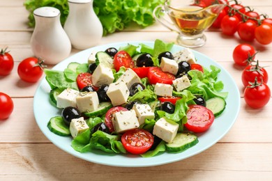 Photo of Delicious salad with feta cheese served on white wooden table, closeup