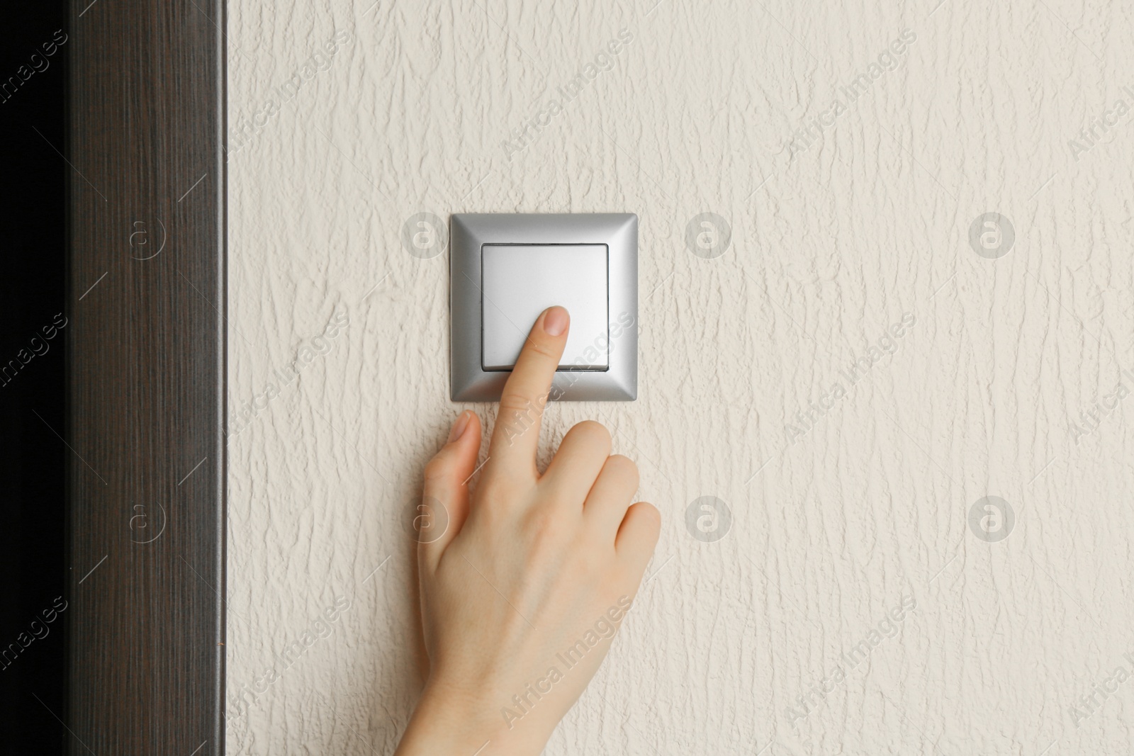 Photo of Woman turning light switch on, closeup view