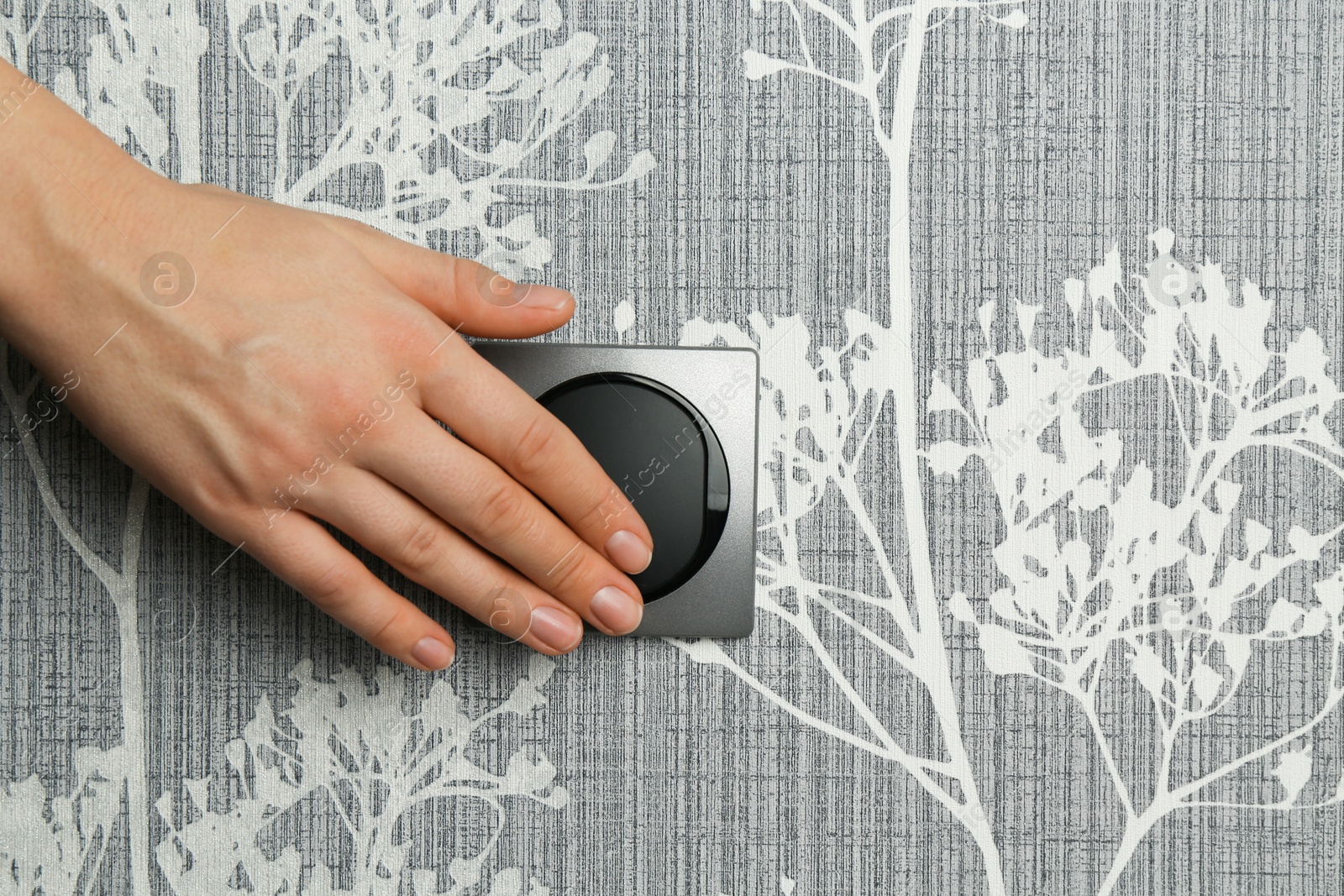 Photo of Woman turning light switch on, closeup view