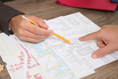 Real estate agent working with client at wooden table, closeup