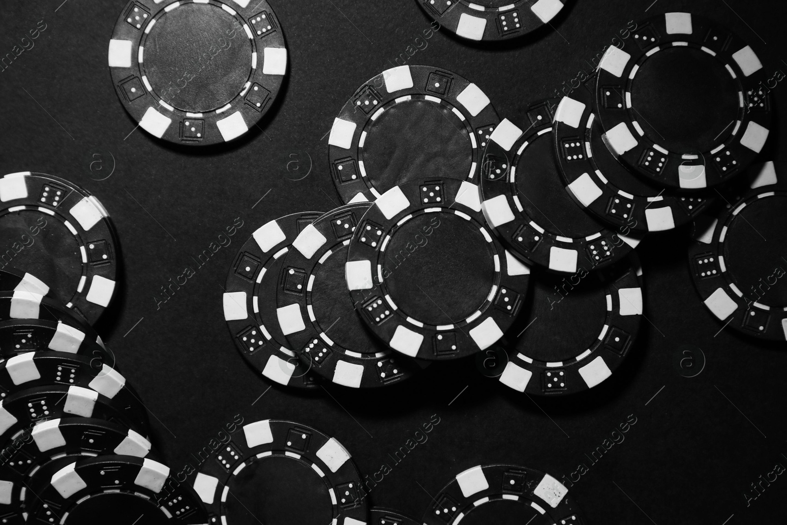 Photo of Poker game. Casino chips on black table, top view