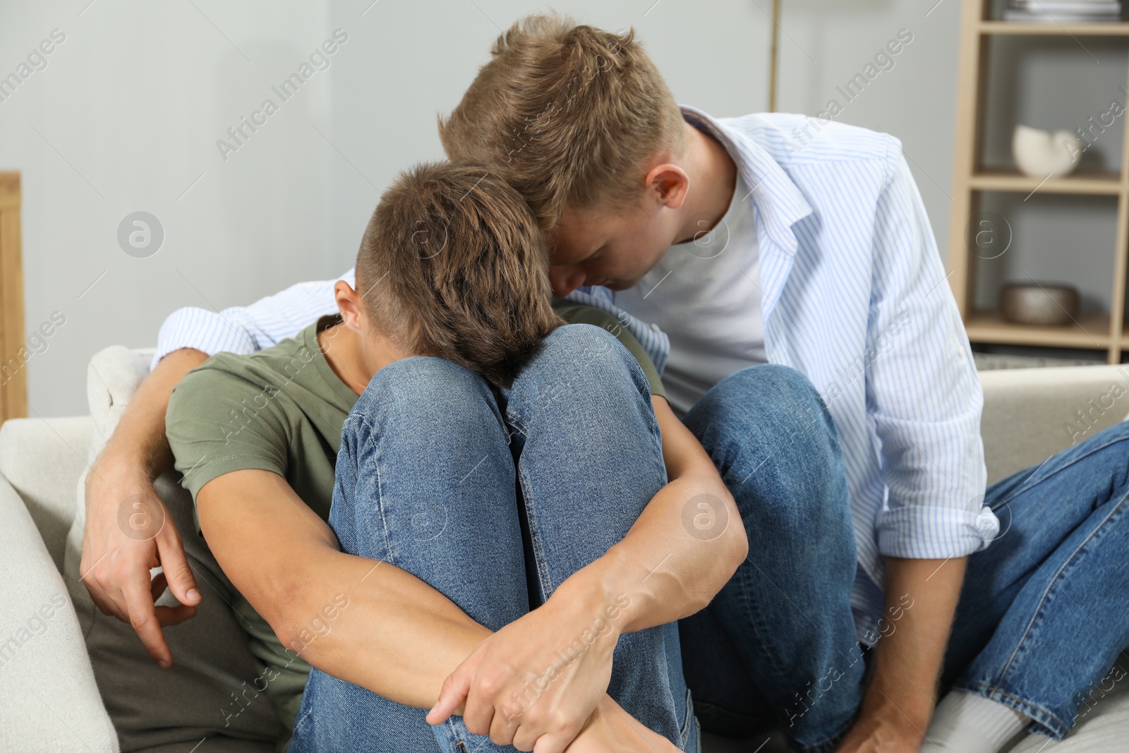 Photo of Young man comforting his brother at home