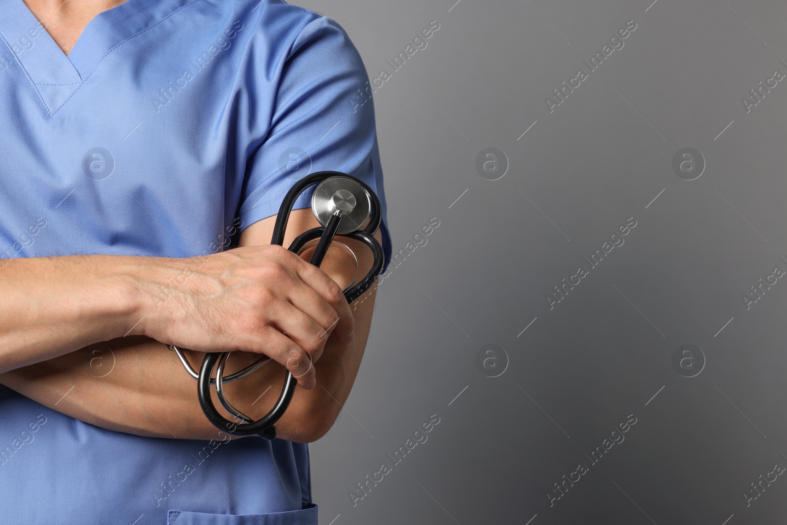 Photo of Nurse with stethoscope on grey background, closeup. Space for text