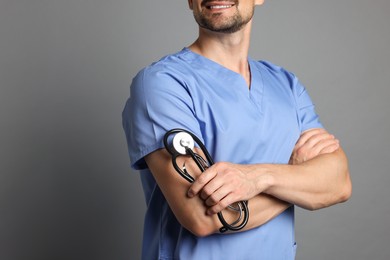 Photo of Nurse with stethoscope on grey background, closeup