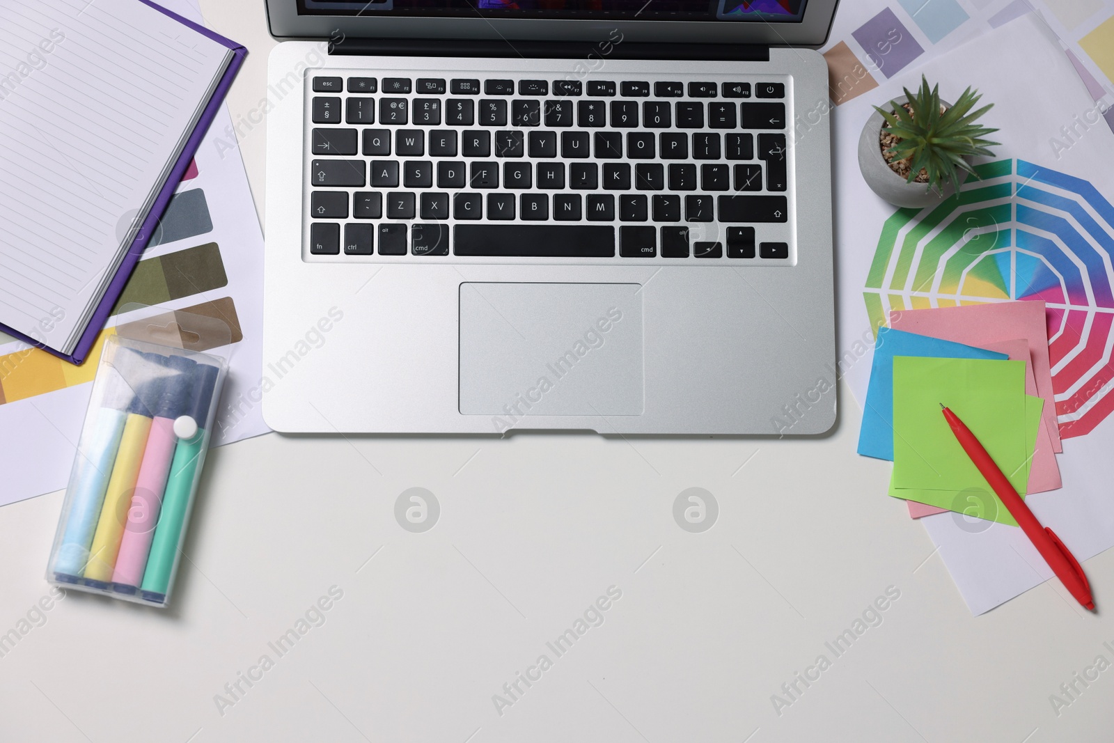 Photo of Designer's workplace with laptop, stationery and palettes on white table, flat lay. Space for text