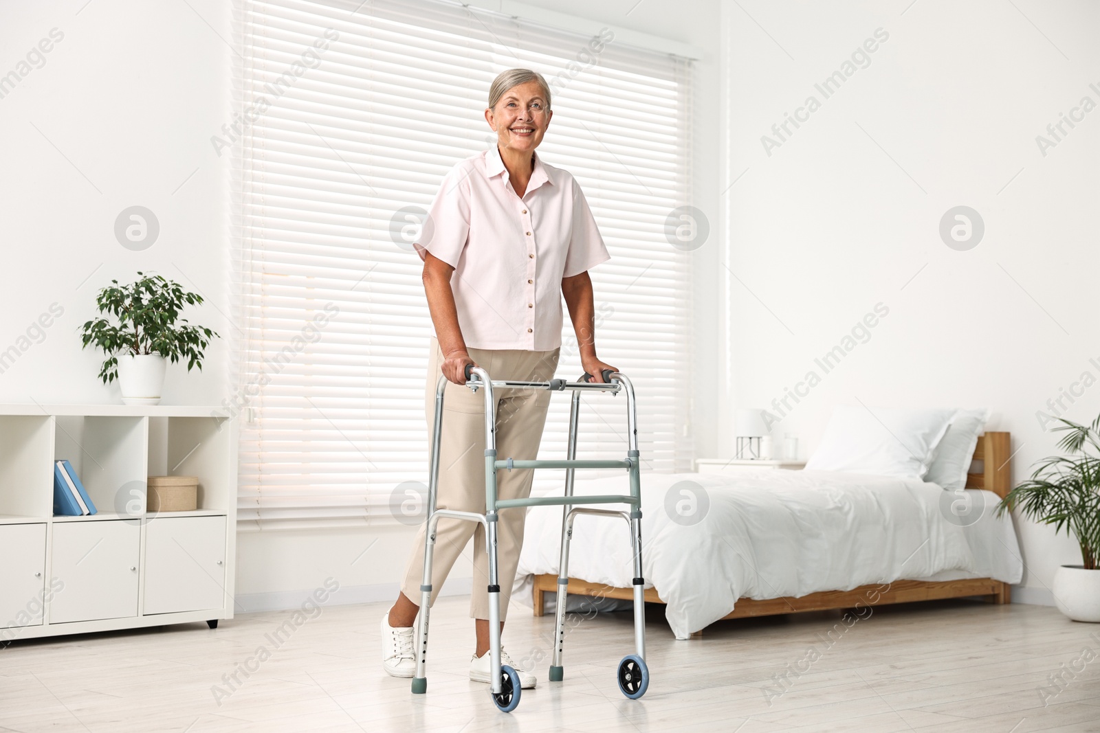 Photo of Senior woman with walking frame in hospital ward