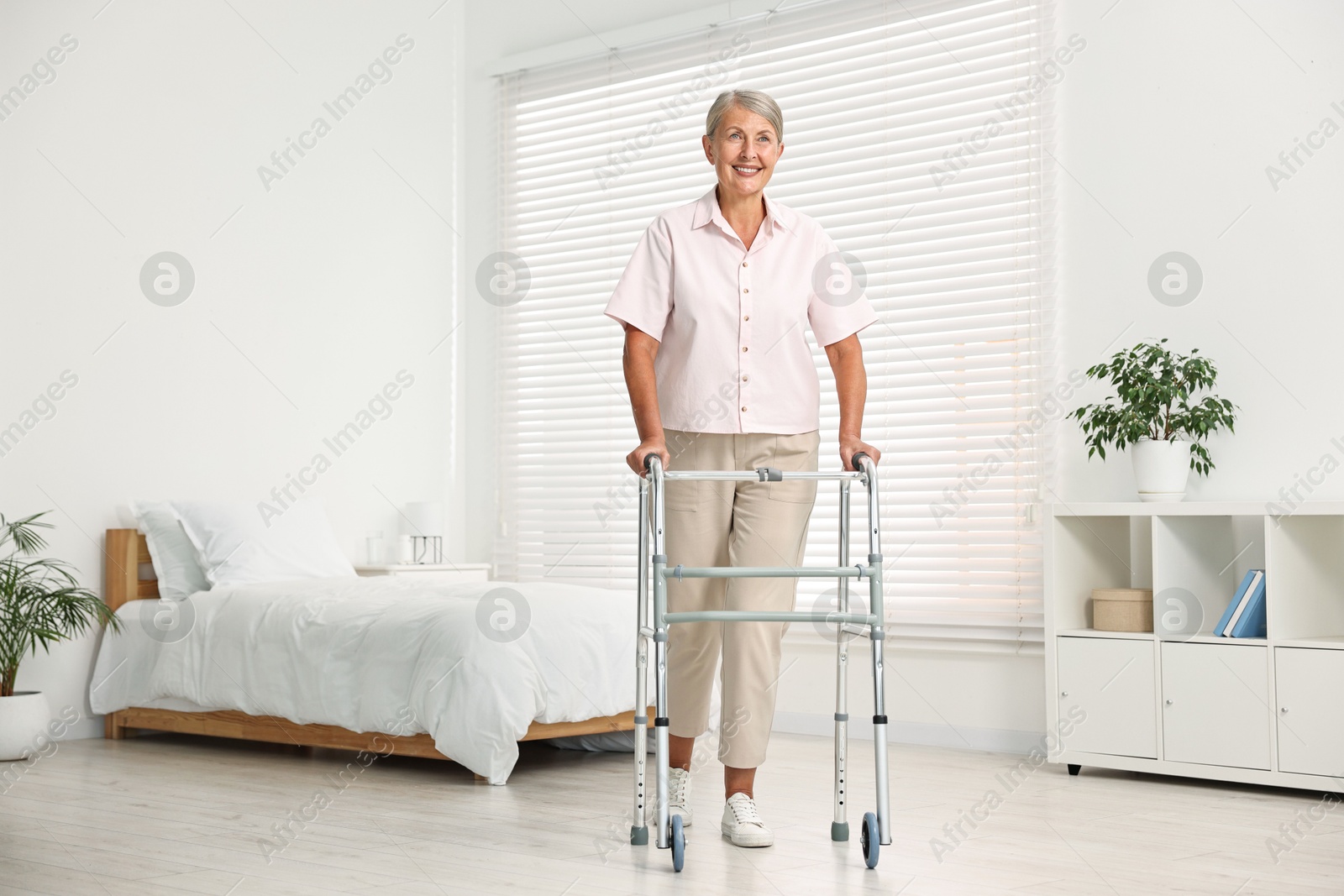 Photo of Senior woman with walking frame in hospital ward