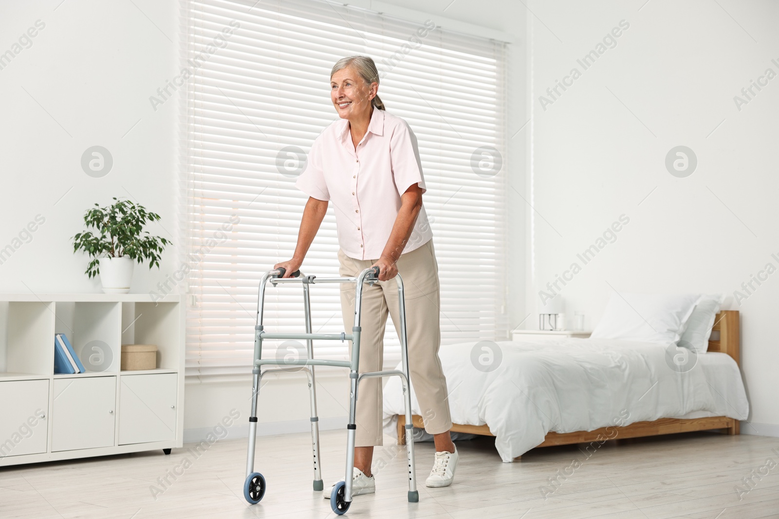 Photo of Senior woman with walking frame in hospital ward