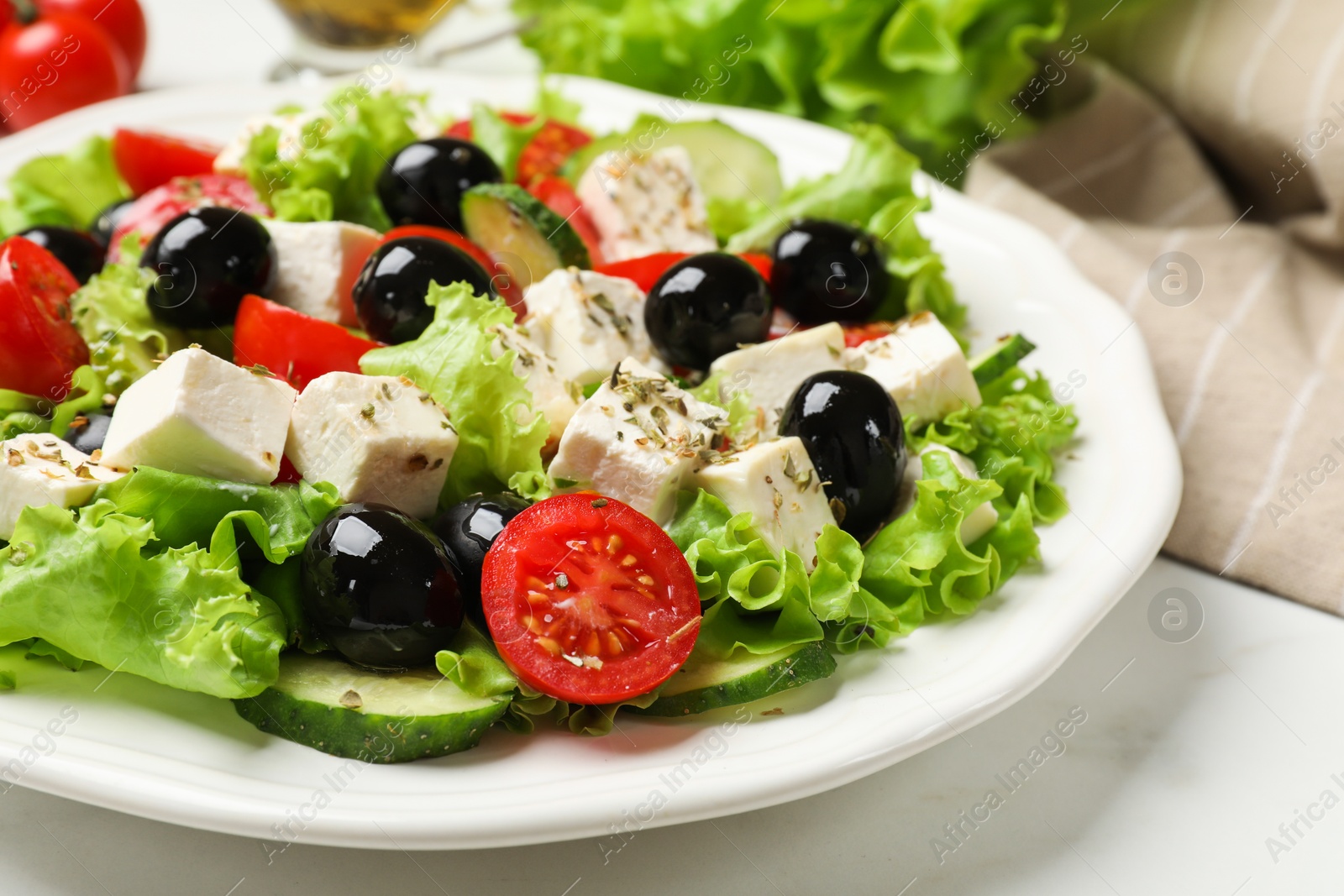 Photo of Delicious salad with feta cheese on white table, closeup