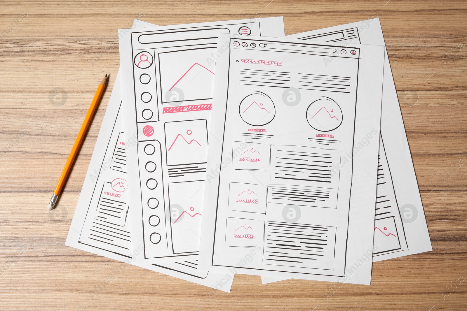 Photo of Website development. Sketches of wireframes and pencil on wooden table, flat lay