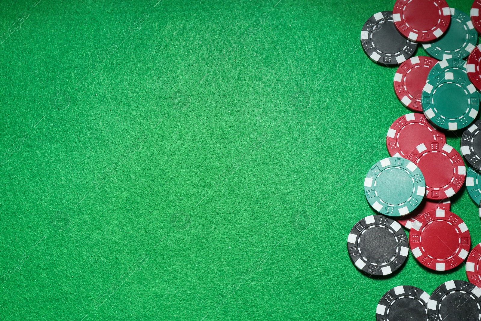 Photo of Poker game. Casino chips on green table, flat lay