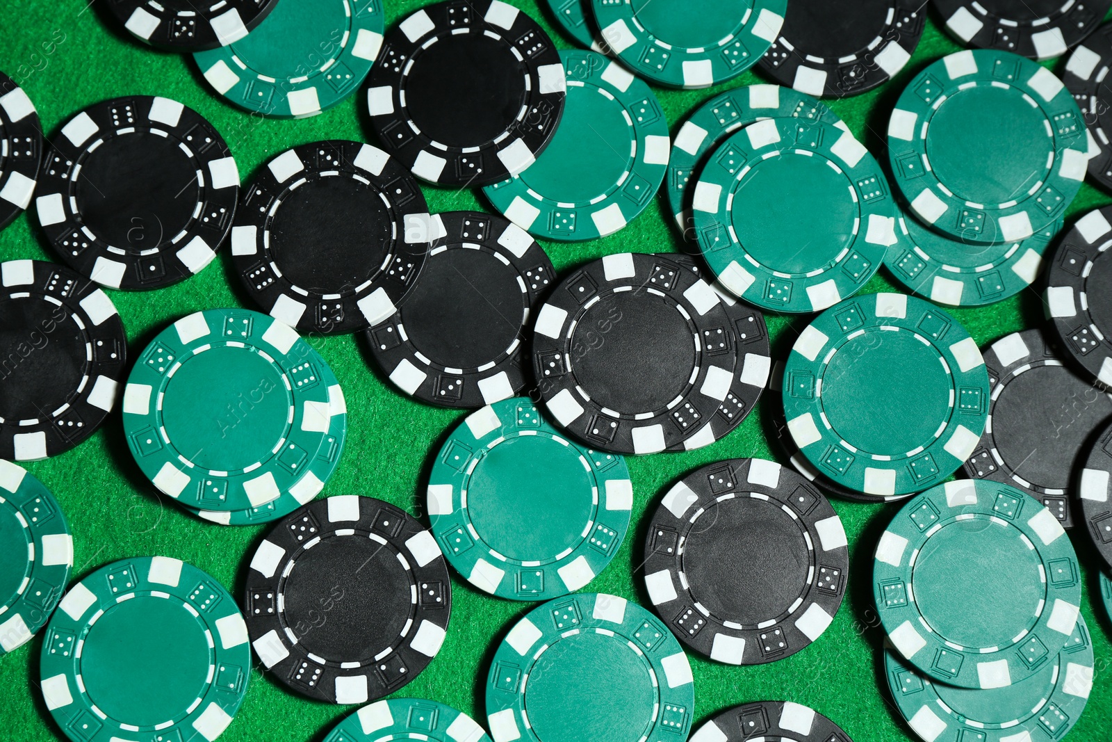 Photo of Poker game. Casino chips on green table, top view