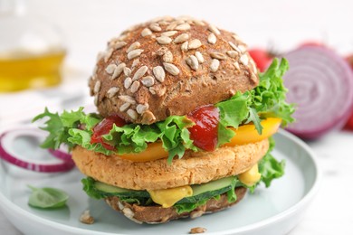 Photo of Delicious vegan burger with chickpea cutlet on white table, closeup