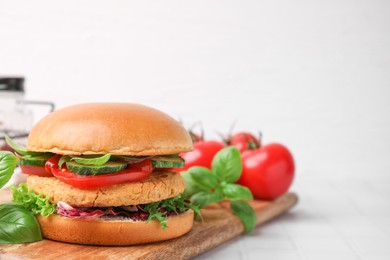 Photo of Delicious vegan burger with chickpea cutlet on white tiled table. Space for text