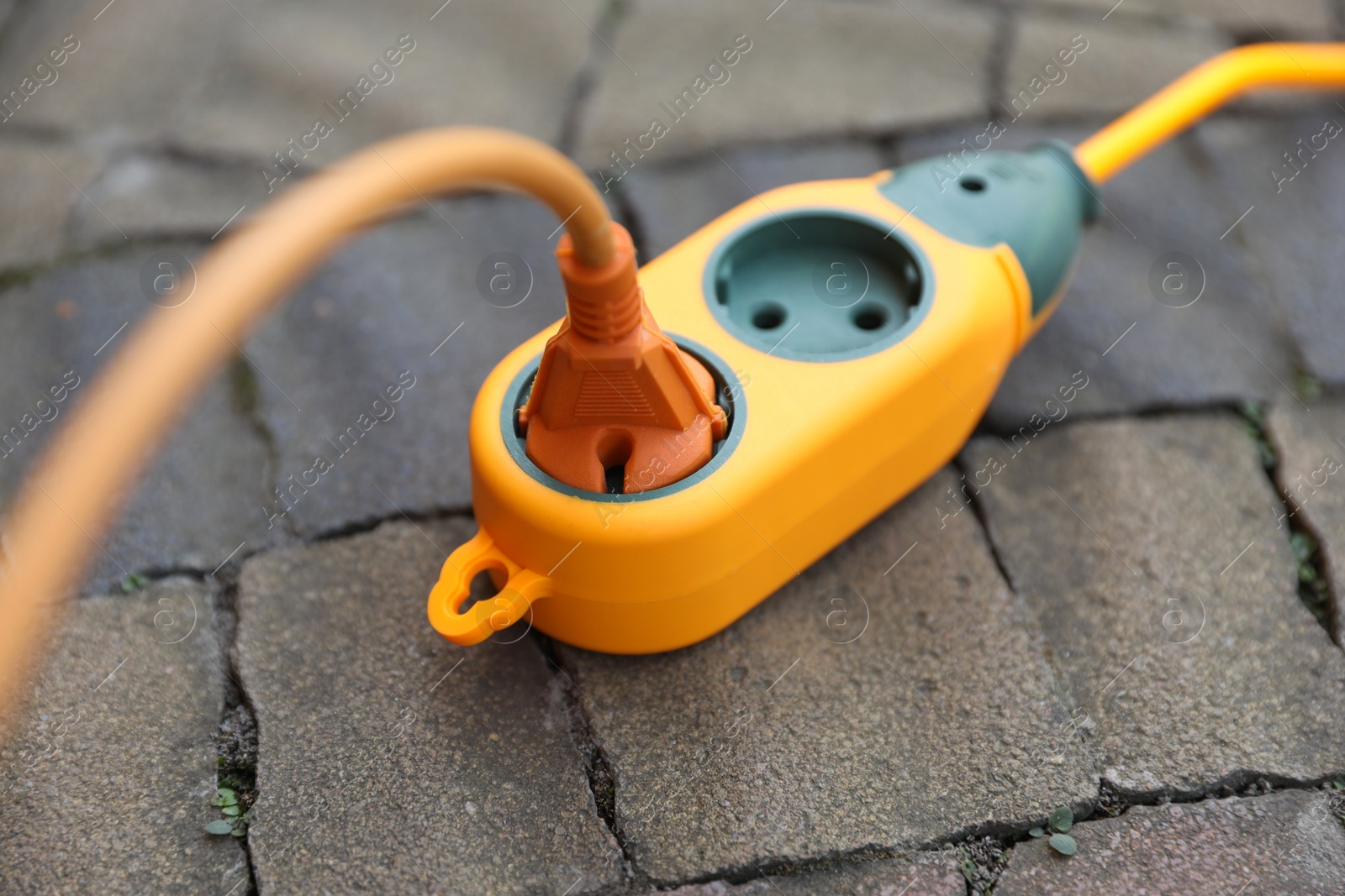 Photo of Extension cord on paved pathway outdoors, closeup