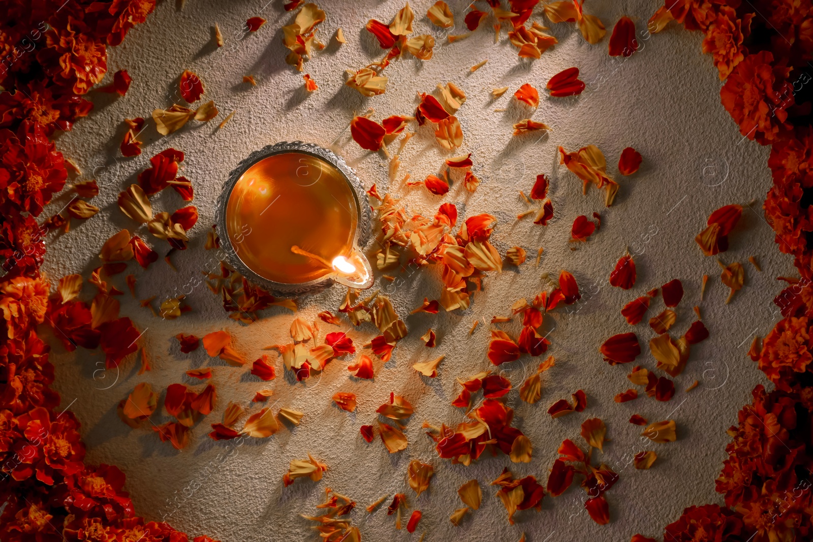 Photo of Diwali celebration. Diya lamp and beautiful flowers on light background, top view