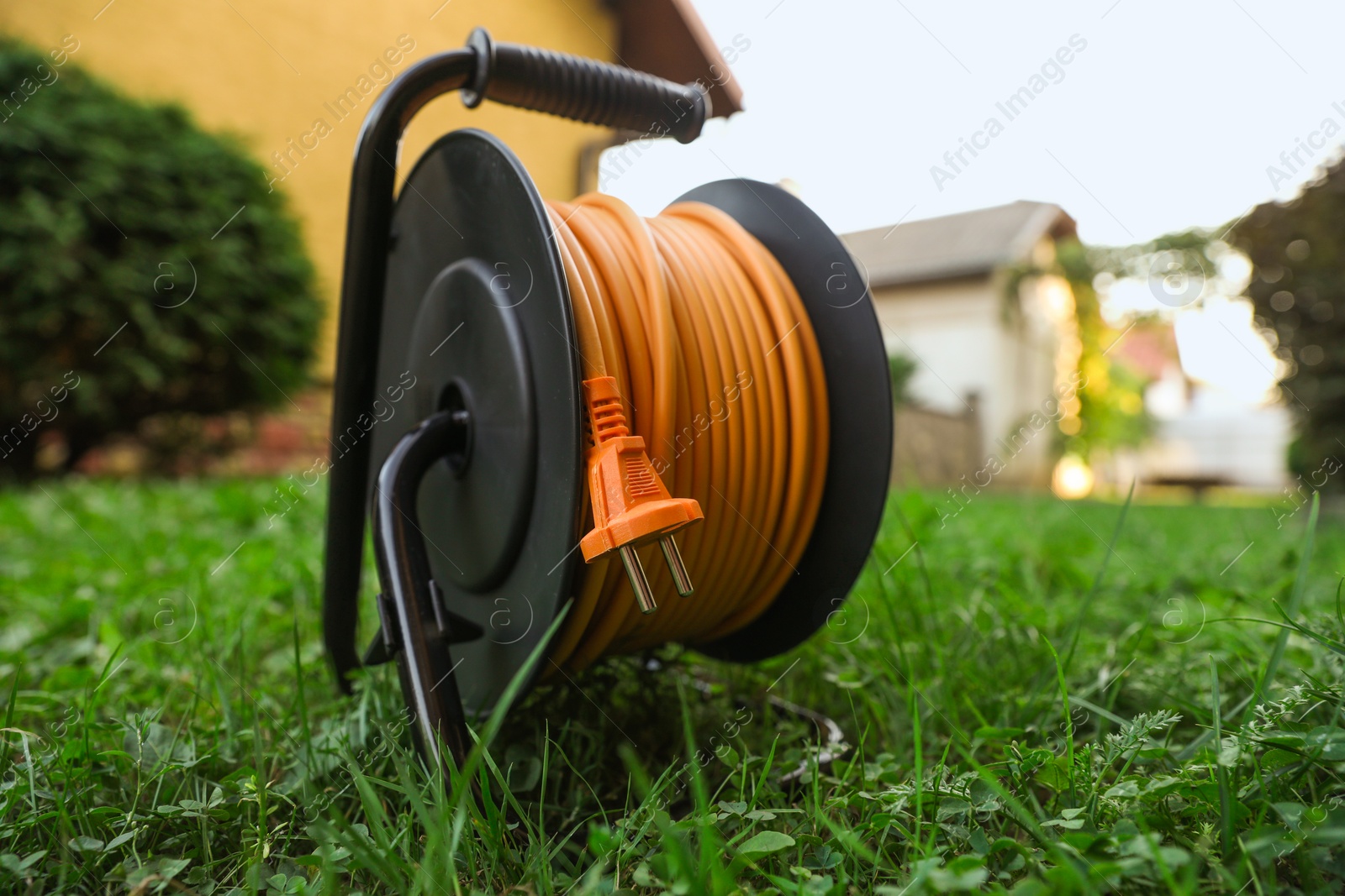 Photo of One extension cord reel on green grass outdoors