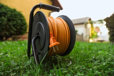 Photo of One extension cord reel on green grass outdoors