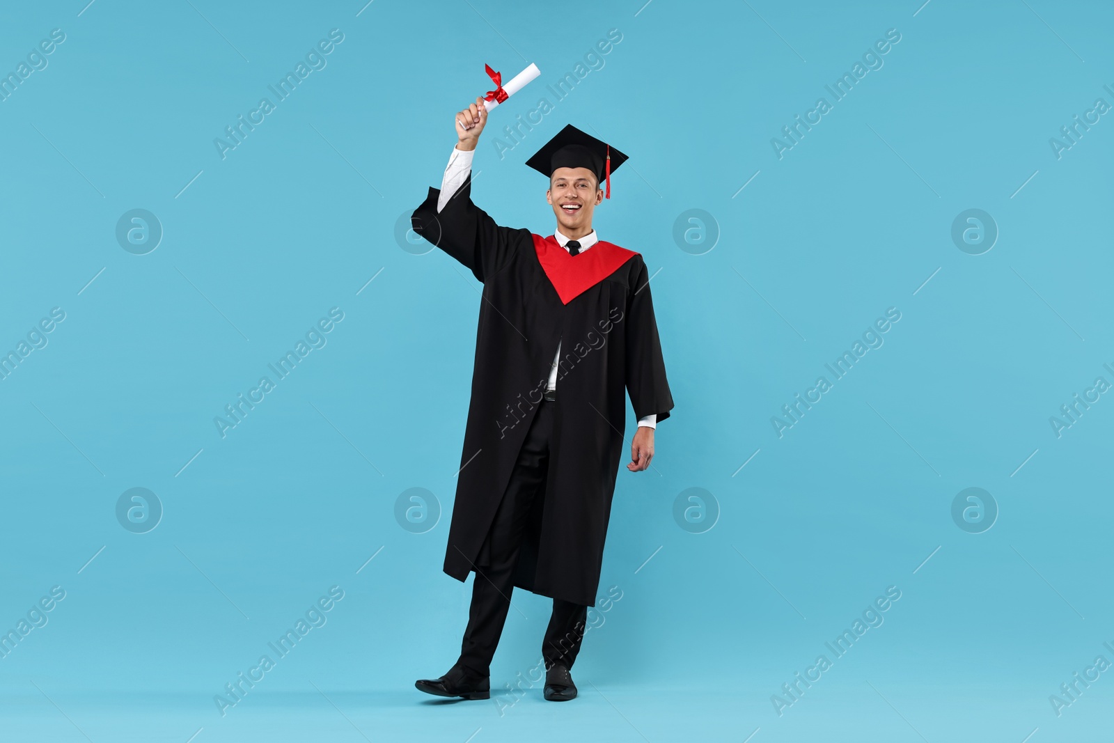 Photo of Happy student with diploma after graduation on light blue background