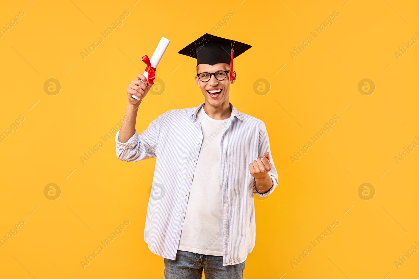 Photo of Happy student with diploma after graduation on orange background