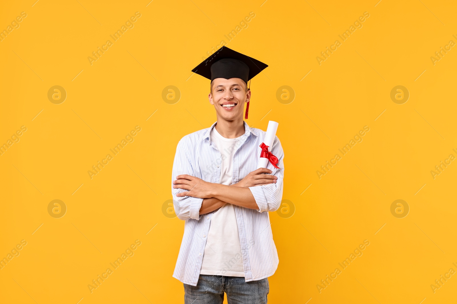 Photo of Happy student with diploma after graduation on orange background