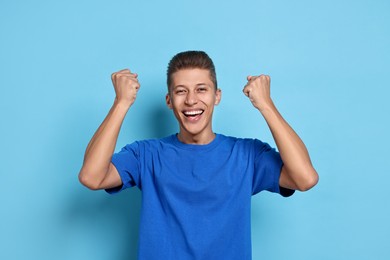 Student feeling happy about his good exam result on light blue background