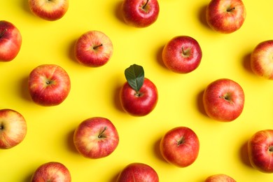 Flat lay composition with many red apples on yellow background