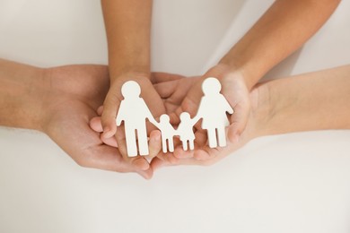 Photo of Parents and child with figures of family on white background, top view