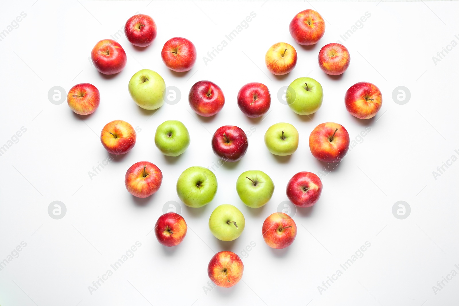 Photo of Heart shape made of red and green apples on white background