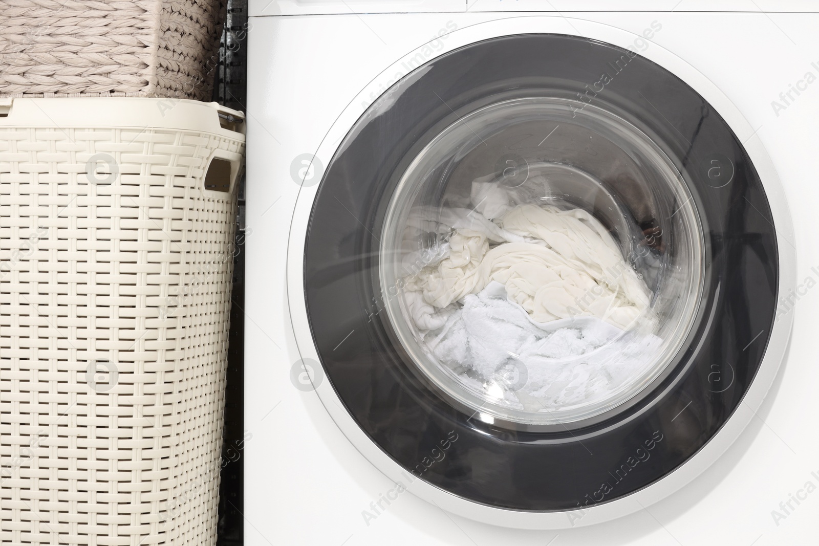 Photo of Washing machine with clothes as background, closeup