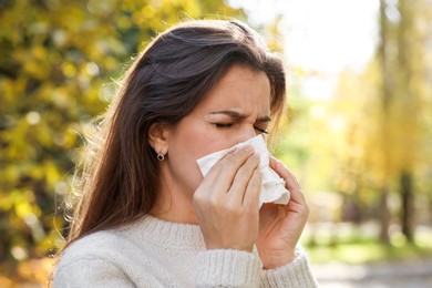 Photo of Young woman with runny nose in park