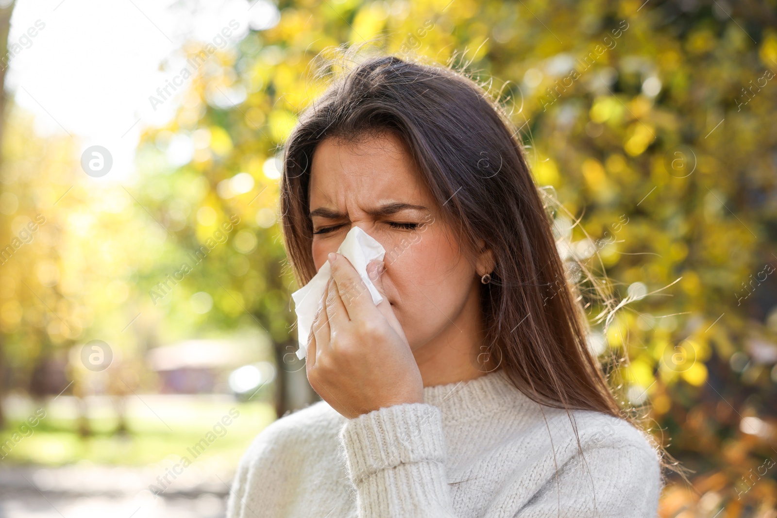 Photo of Young woman with runny nose in park