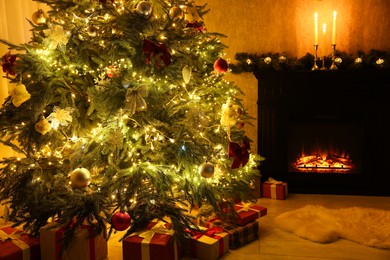 Photo of Beautifully decorated Christmas tree, gifts and fireplace in room