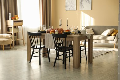 Photo of Stylish dining room with beautiful table setting and autumn decor